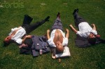 England - London - Three city office workers sunbathe during hot lunchtime